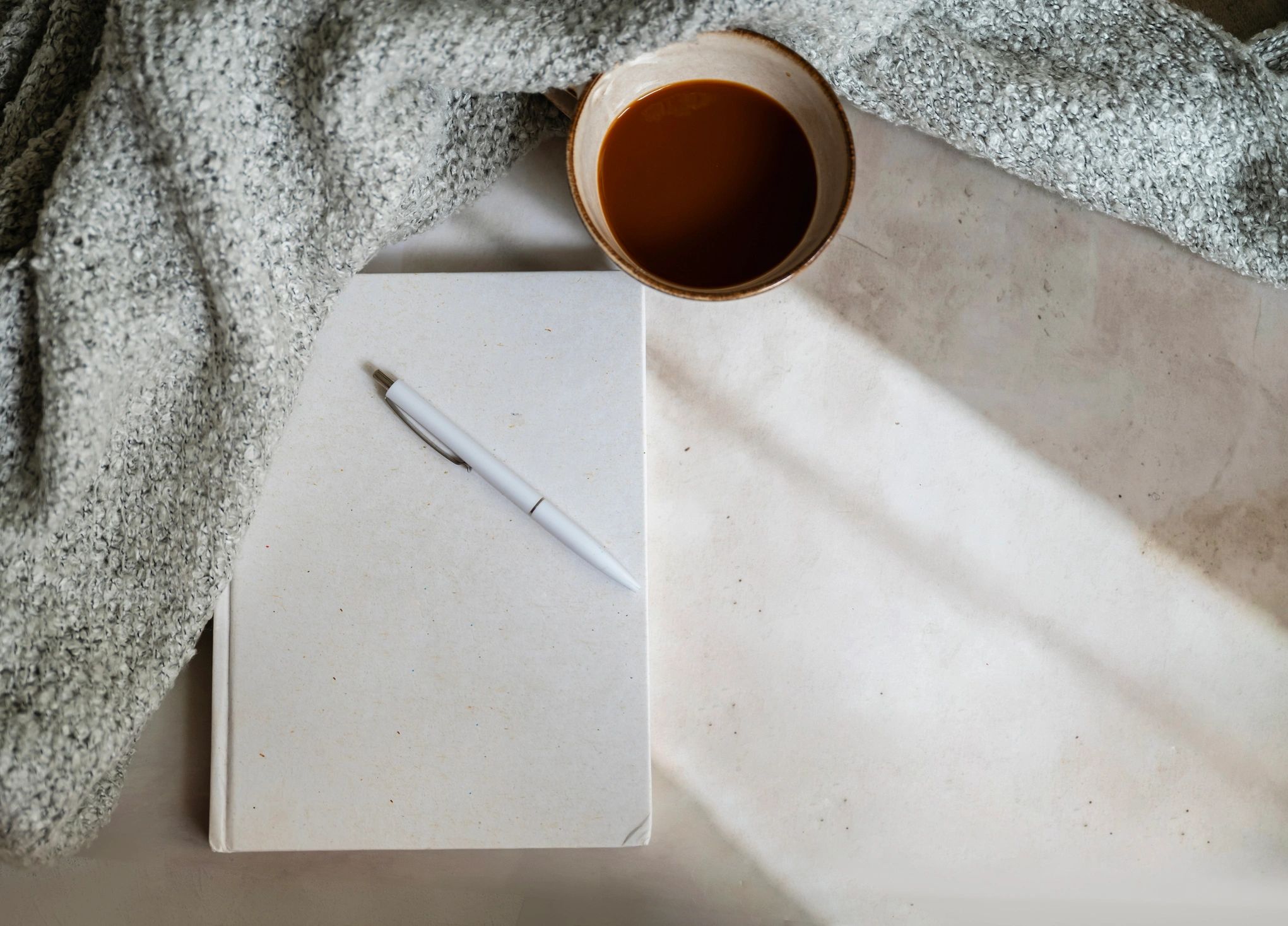Notebook and coffee representing reflective reading resources