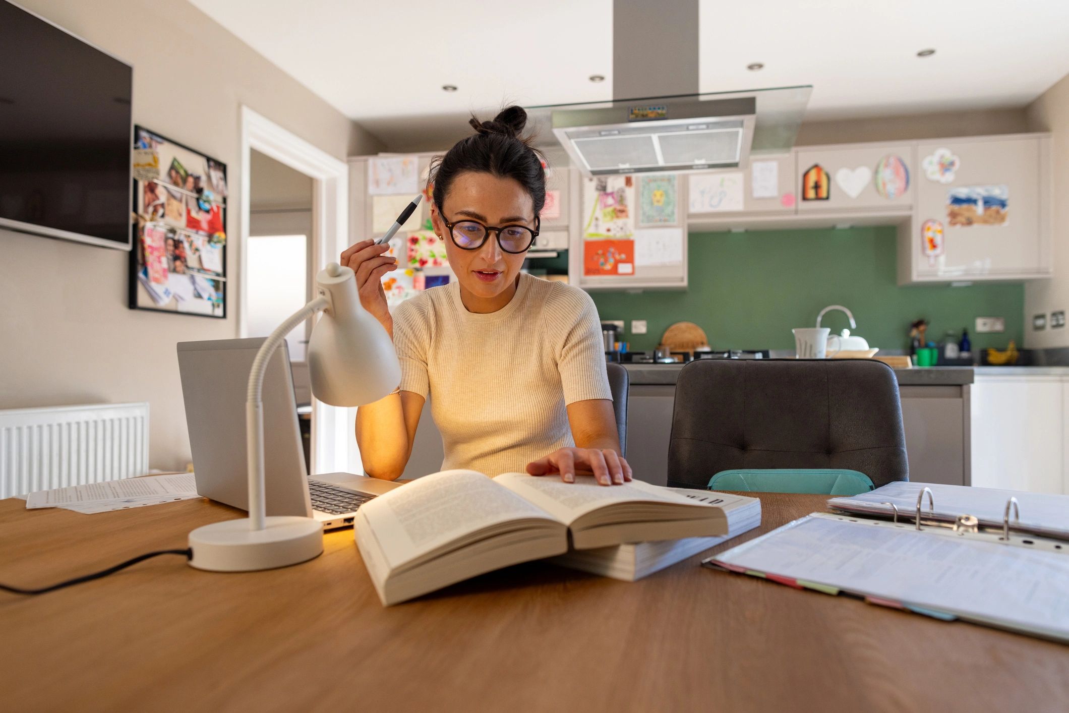 Woman reading and studying at a table with books and notes